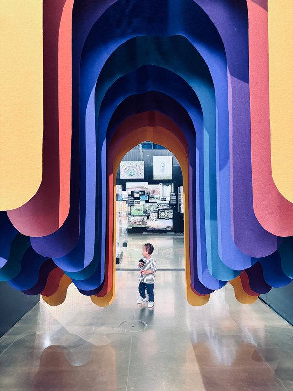 A child in a rainbow archway